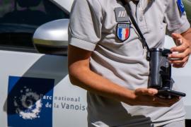 Gros plan sur les écussons d'un agent du Parc, devant une voiture