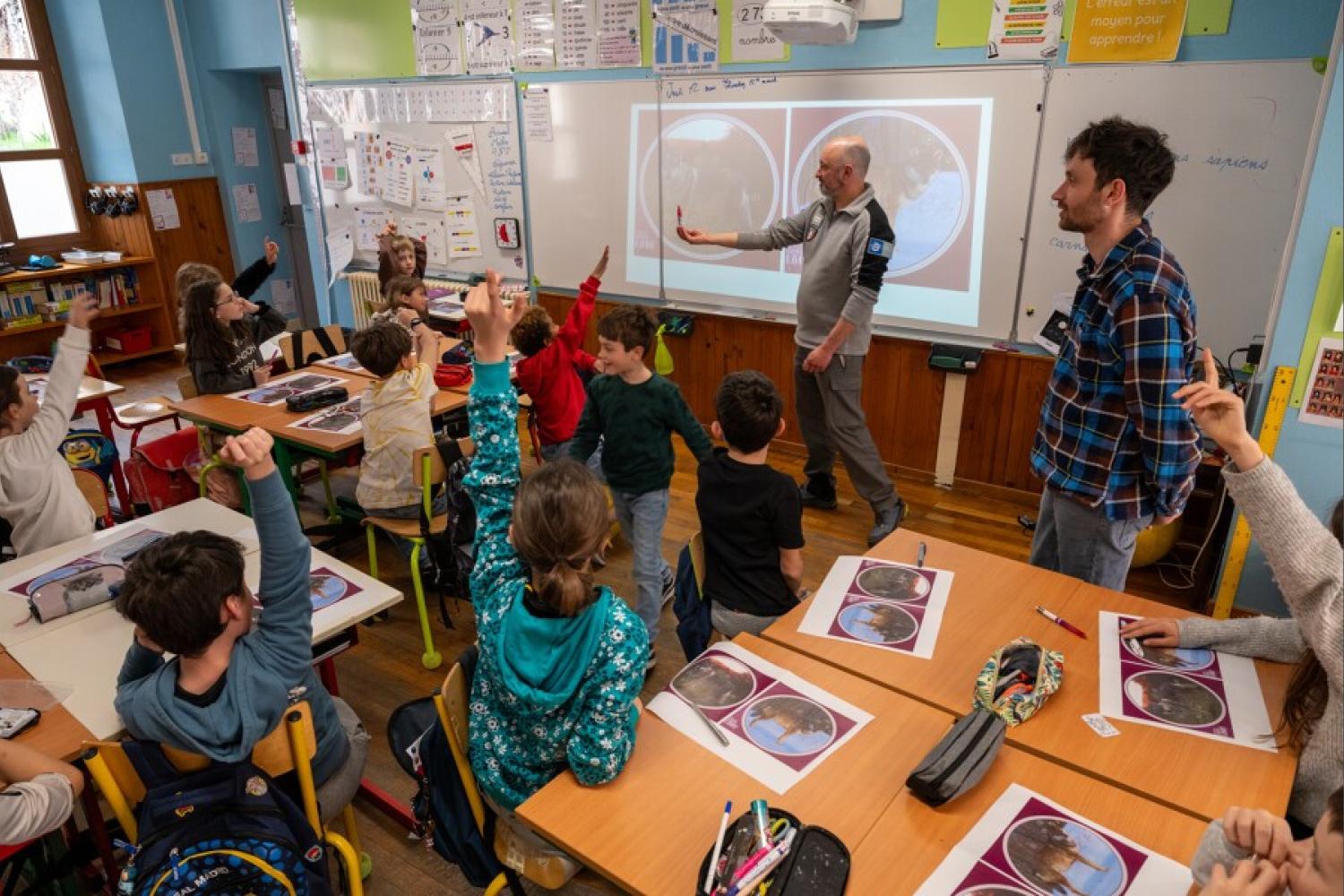 Une vue d'ensemble d'une classe avec les élèves levant la main