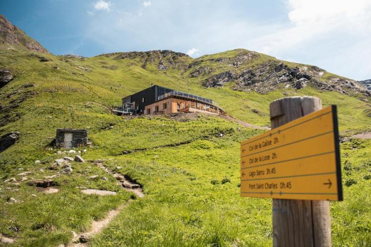 Panneau de randonnées avec le refuge de Prariond au loin en été - Panneau de randonnées avec le refuge de Prariond au loin en été